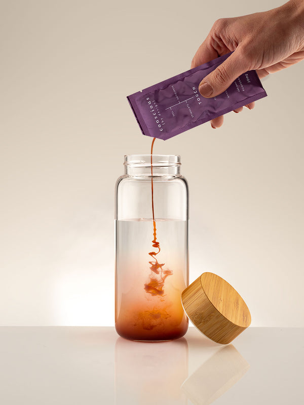 Wellness pour being poured into bottle of water